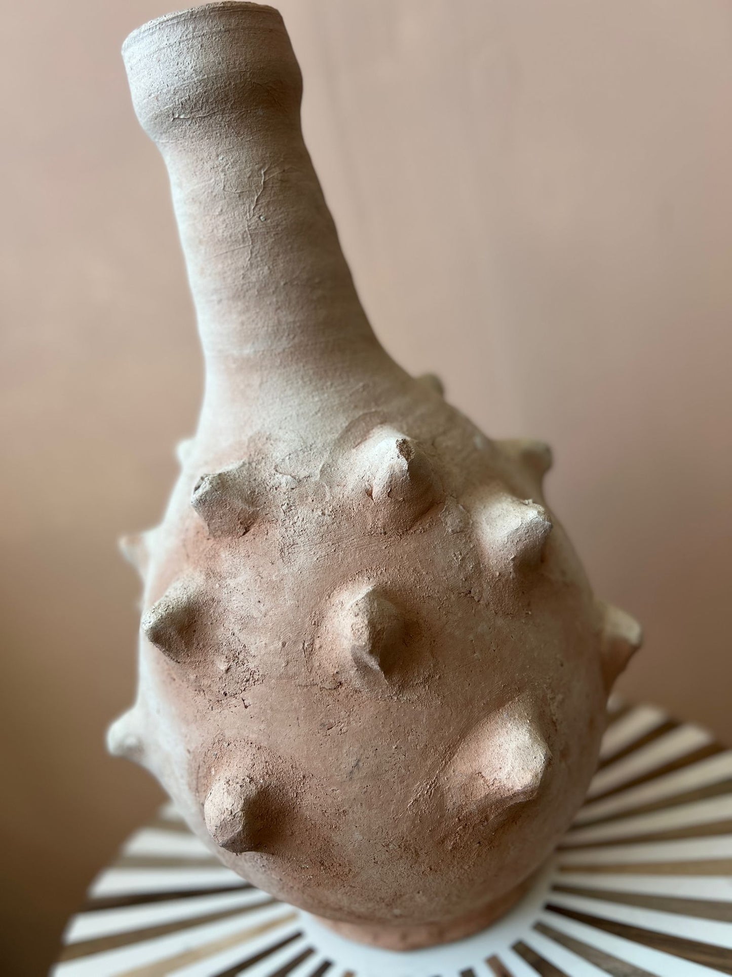 Detailaanzicht van unieke Marokkaanse vaas met ruwe textuur en stekels, ambachtelijk gevormd uit terracotta.