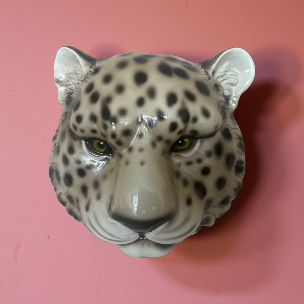 Luipaardhoofd wanddecor tegen een roze muur – een krachtig statement piece.