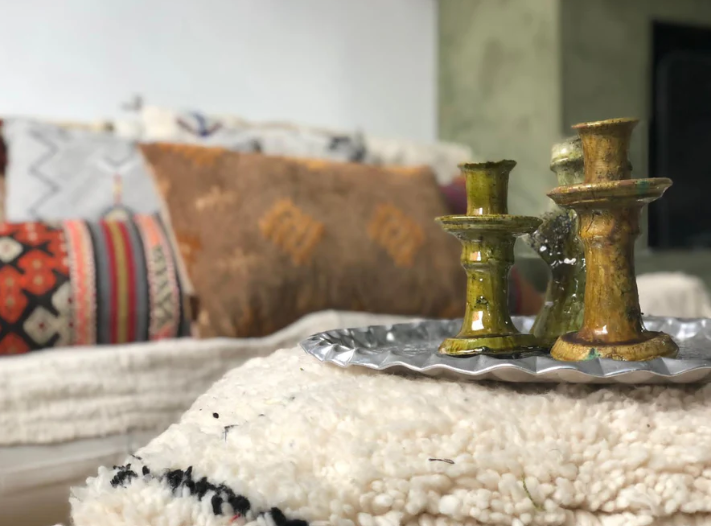 Beni Ouarain poef gebruikt als bijzettafel met decoratief dienblad en kandelaars, gestyled in een bohemian interieur.
