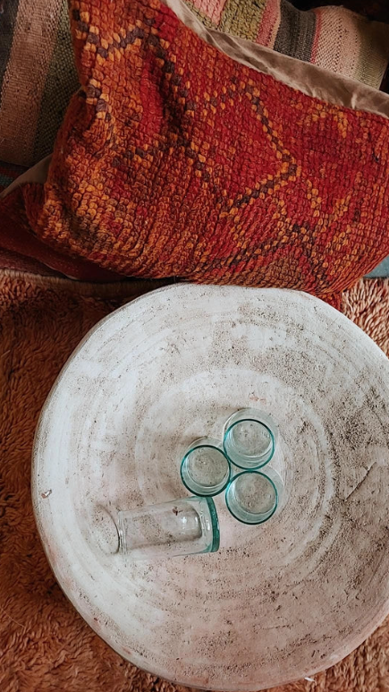 Handgemaakte naturel Tamegroute schaal van 50 cm, gestyled met Marokkaanse glazen en warme interieurdetails.