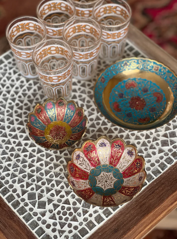 Handgemaakte koperen schaaltjes in een Marokkaanse setting met andere accessoires.