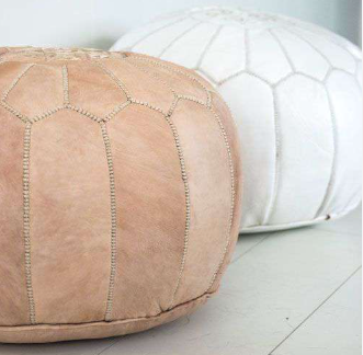 Nude en witte handgemaakte leren poefen gestyled in een modern interieur.