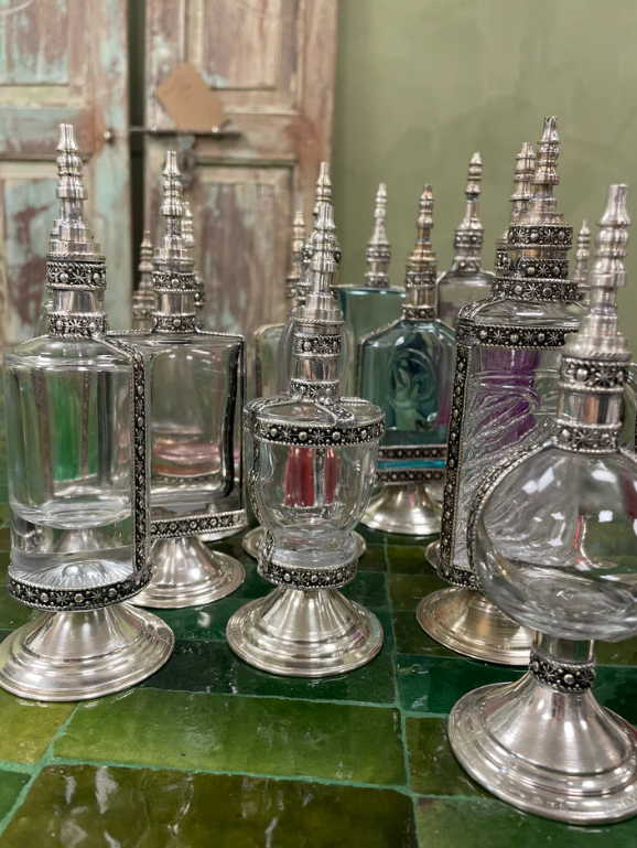 Set van luxe vintage parfumflesjes met uniek ontwerp en verzilverde accenten.