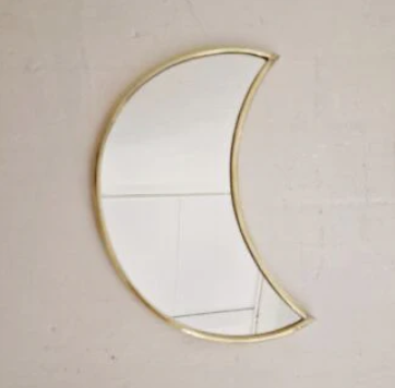 Handgemaakte spiegel in de vorm van een halve maan met messing rand, perfect voor een luxe interieur.