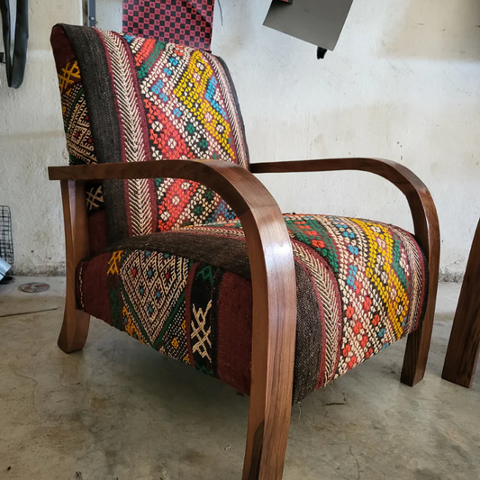 Handgemaakte notenhouten Kelim-stoel met kleurrijk patroon, gestyled in een modern interieur.